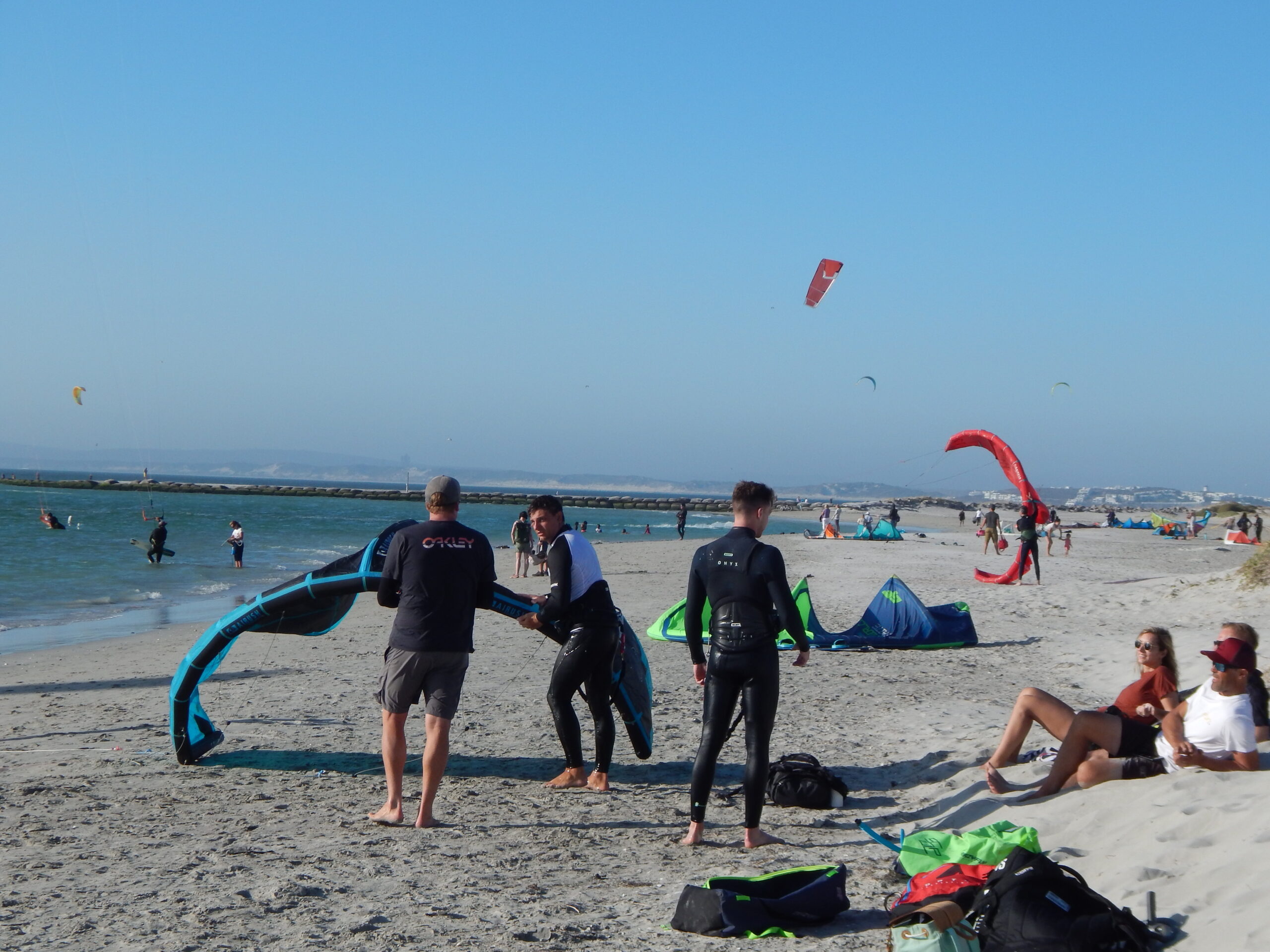 C-Kite instructors and kiteboarders preparing equipment on the beach in Langebaan