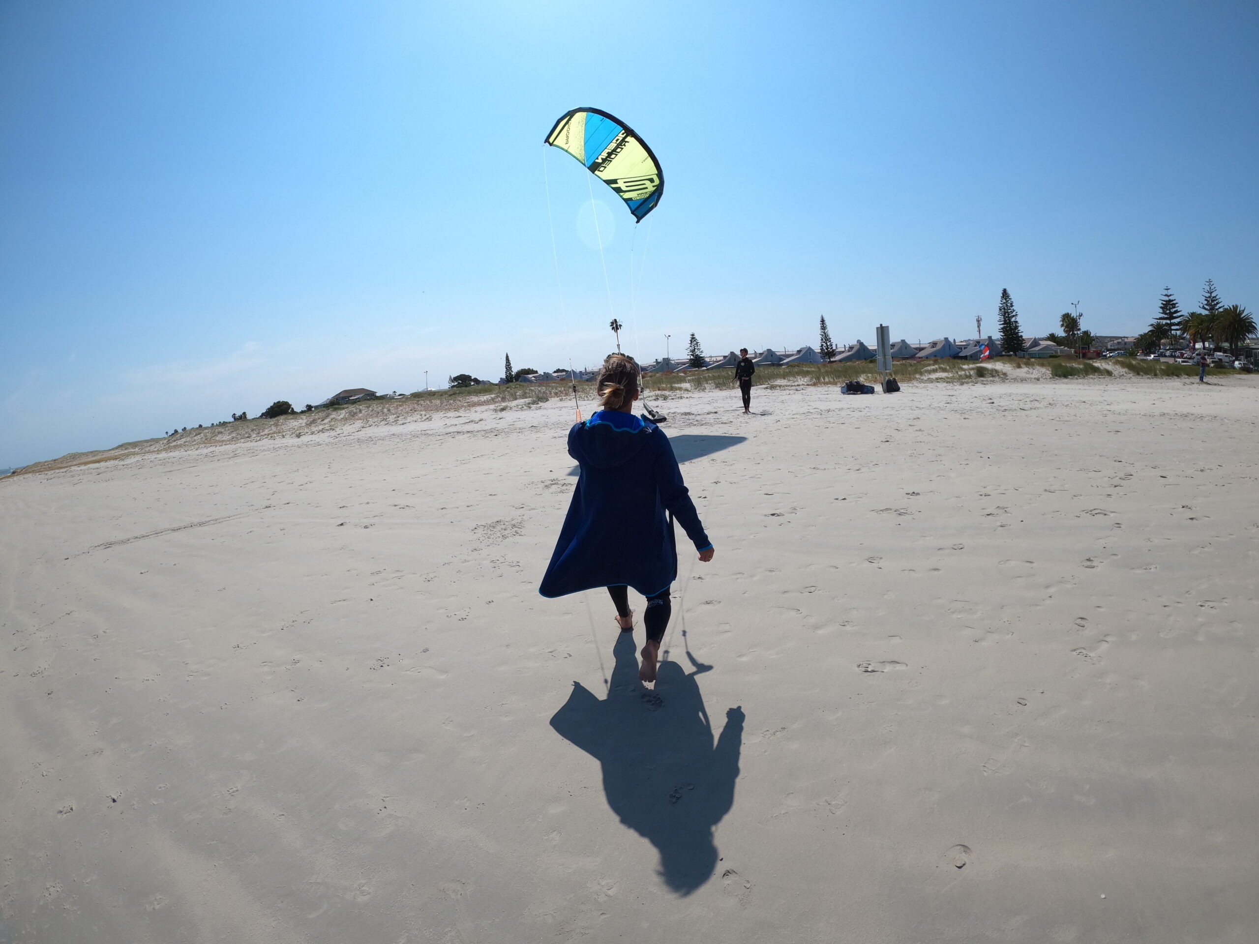 Walking across the Langebaan beach while preparing a kite for the water